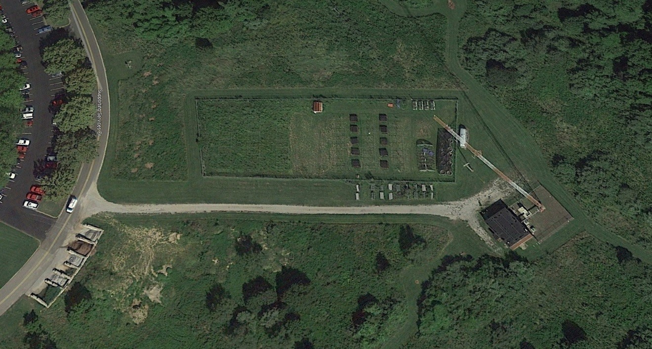 A cold-frame greenhouse on a 1-acre field research site.